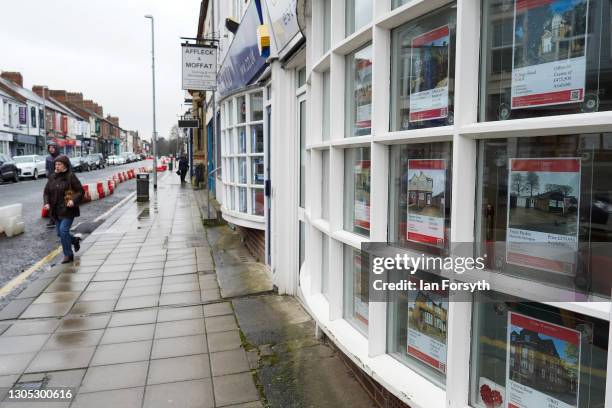 Woman walks past an estate agents window in Darlington after it was announced by the Chancellor of the Exchequer Rishi Sunak that the town will...