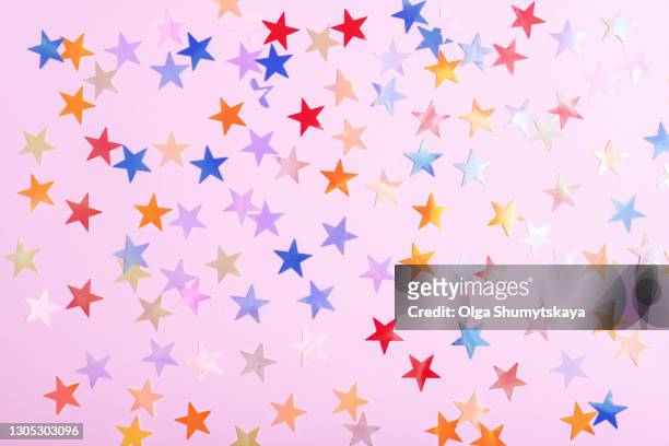 a scattering of multicolored sparkles of stars on a pink background - work anniversary ストックフォトと画像