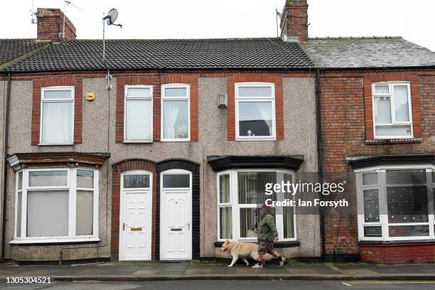 Man walks his dog along a residential street in Darlington after it was announced by the Chancellor of the Exchequer Rishi Sunak that the town will...