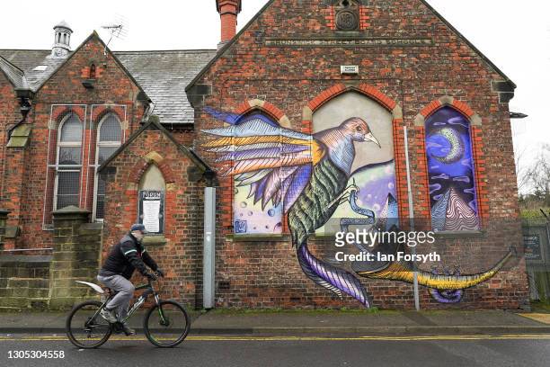 Man cycles past a mural painted on a wall in Darlington after it was announced by the Chancellor of the Exchequer Rishi Sunak that the town will...