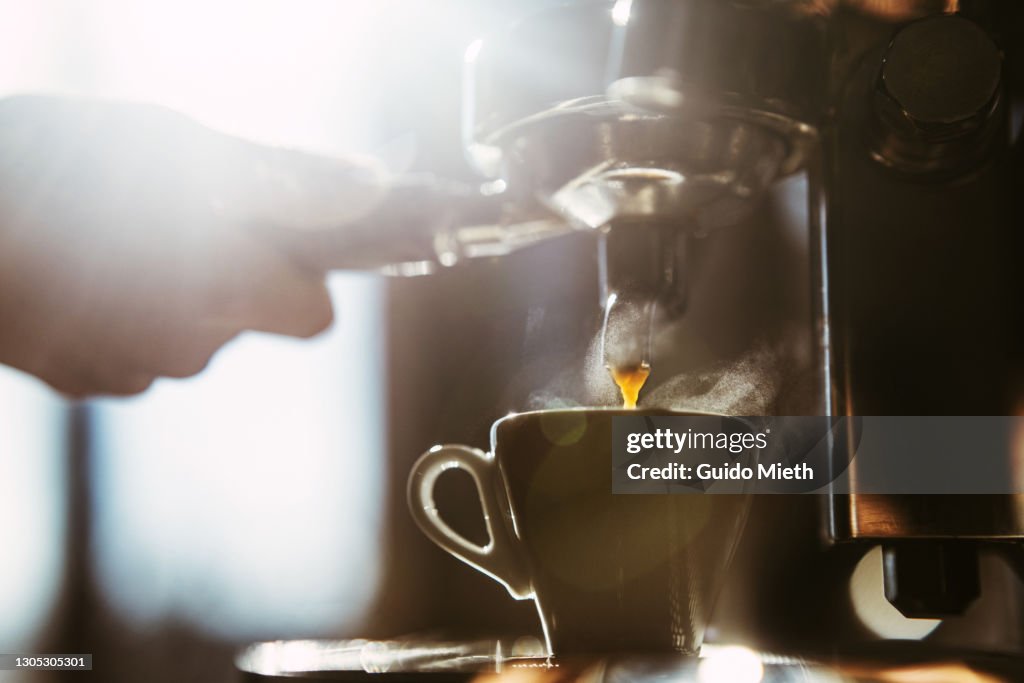 Woman making espresso coffee.