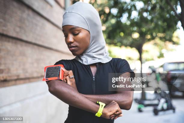 muslim woman running wit a sport hijab - computador utilizável como acessório imagens e fotografias de stock