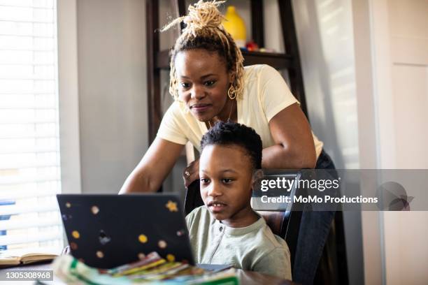 mother helping son during e-learning at home - kids homework stock pictures, royalty-free photos & images