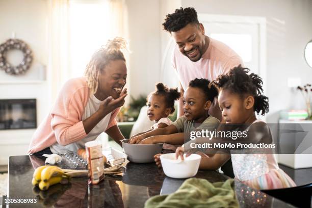 family mixing cookie dough at home - african american ethnicity stock-fotos und bilder