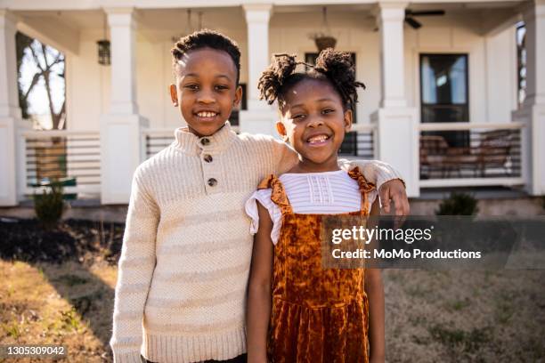 portrait of brother and sister in front of home - brothers boys cuddle stock pictures, royalty-free photos & images