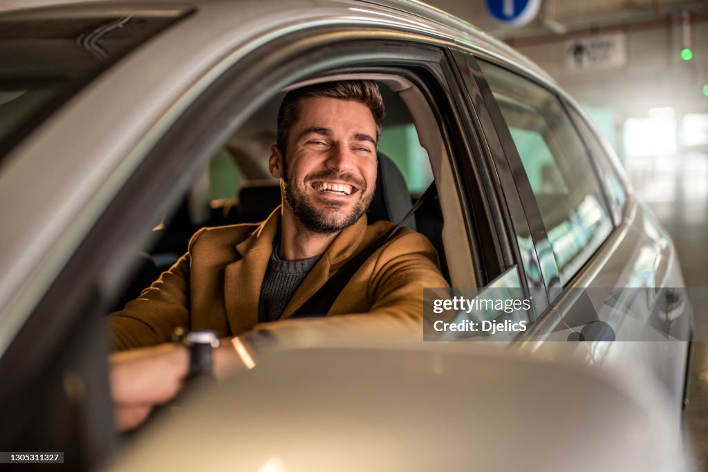 Mens die een auto in openbare garage drijft.