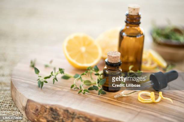 essential oils with thyme and lemon - aromatherapy oil stock pictures, royalty-free photos & images