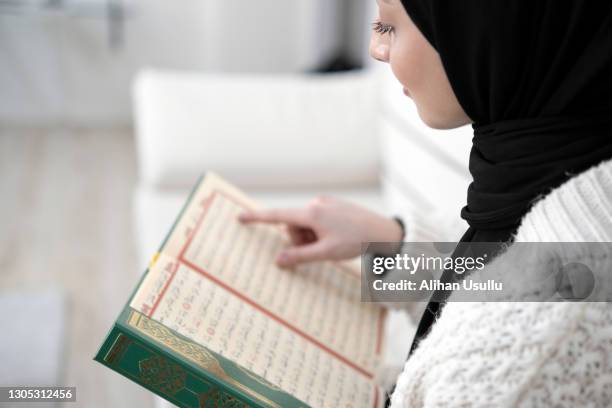 muslim young woman reading koran - koran imagens e fotografias de stock