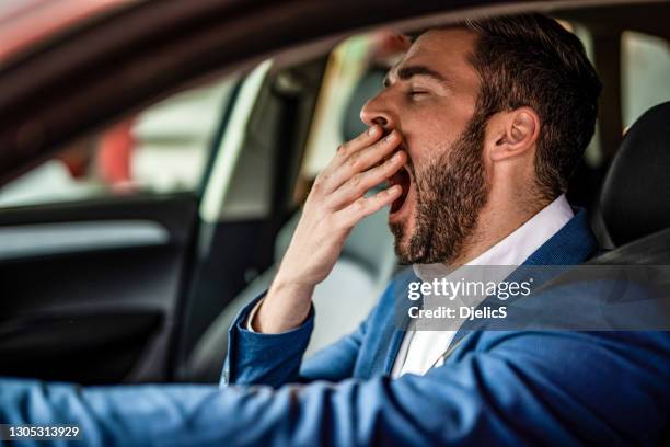 mens die een auto bestuurt en geeuwt. - yawning stockfoto's en -beelden