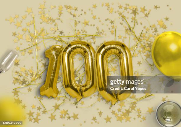 100 foil golden ballon in gold background - night 100 stock pictures, royalty-free photos & images