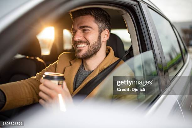 gelukkige medio volwassen mens die een auto op zonsondergang drijft. - leisure work coffee happy stockfoto's en -beelden