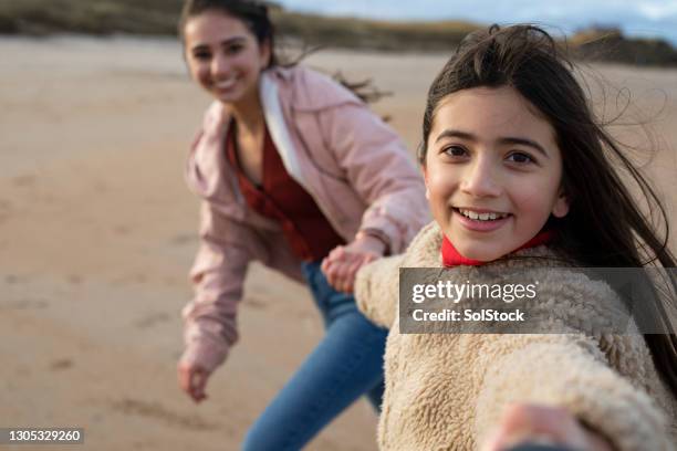 spinning on the beach con mia sorella - mother running foto e immagini stock