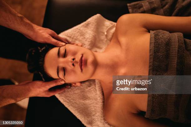 joven recibiendo masaje en la cabeza - head massage fotografías e imágenes de stock