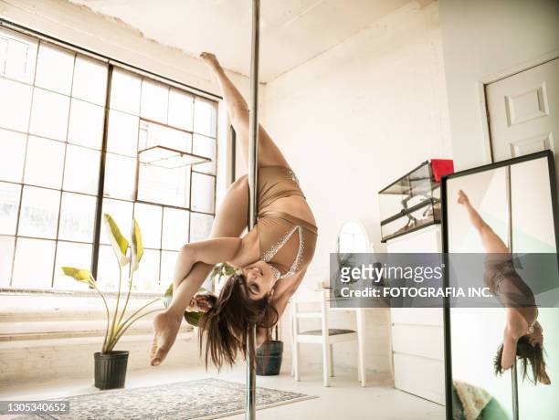 female aerial dancer on flying pole - pole dance stock pictures, royalty-free photos & images