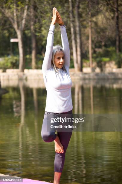 senior woman practicing yoga tree pose - stretching stock pictures, royalty-free photos & images