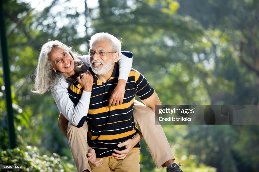 Senior man piggybacking his wife