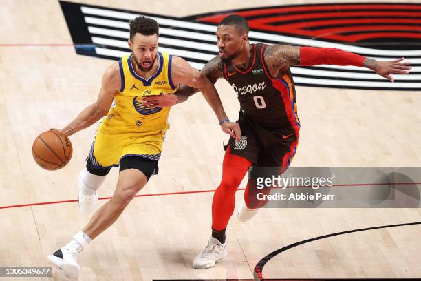 Stephen Curry of the Golden State Warriors dribbles against Damian Lillard of the Portland Trail Blazers in the first quarter at Moda Center on March...