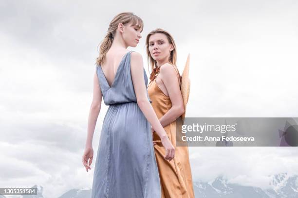 beautiful girls are walking in the mountains. majestic nature. long dresses to the floor. tourist trip. - white dress back stock pictures, royalty-free photos & images