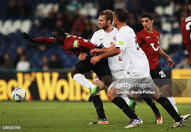 Didier Ya Konan of Hannover and Jan Kirchhoff and Nikolce Noveski of Mainz battle for the ball during the DFB Pokal second round match between...