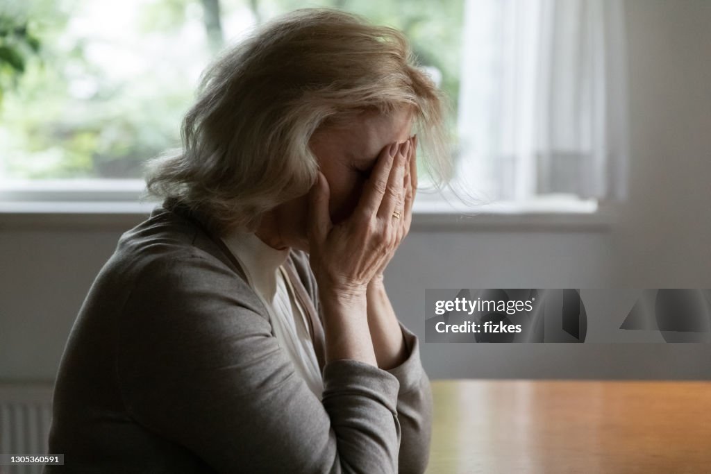 Depressed mature OAP 60s woman going through crisis