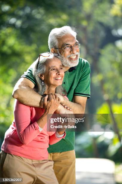 happy senior couple admiring view at park - old couple stock pictures, royalty-free photos & images