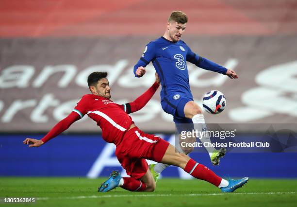 Timo Werner of Chelsea is challenged by Ozan Kabak of Liverpool as he scores his team's first goal during the Premier League match between Liverpool...