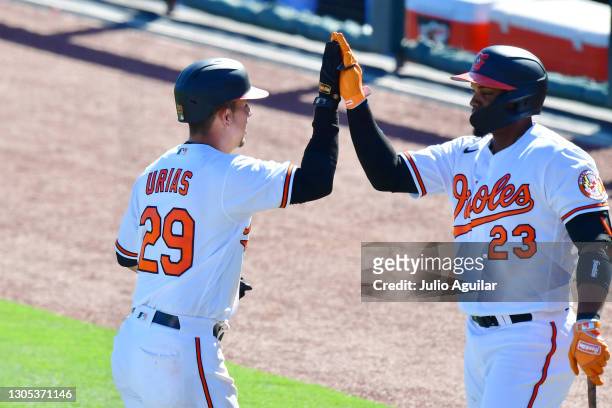 Ramon Urias and Yusniel Diaz of the Baltimore Orioles high five after Urias hit a 3-run home run in the fifth inning against the Boston Red Sox...