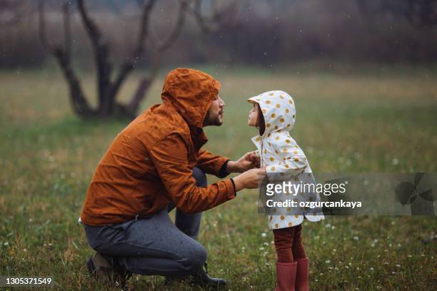 happy father and little girl picking flowers - rain kiss stock pictures, royalty-free photos & images