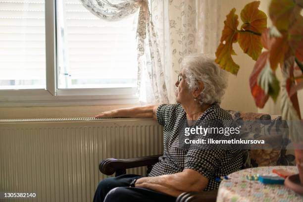 old woman self isolating during coronavirus outbreak - loneliness coronavirus stock pictures, royalty-free photos & images