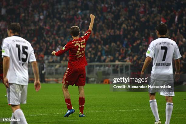 Thomas Mueller of Muenchen celebrates scoring the opening goal beside Tobias Fink of Ingolstadt and his team mate Christopher Knasmuellner during the...