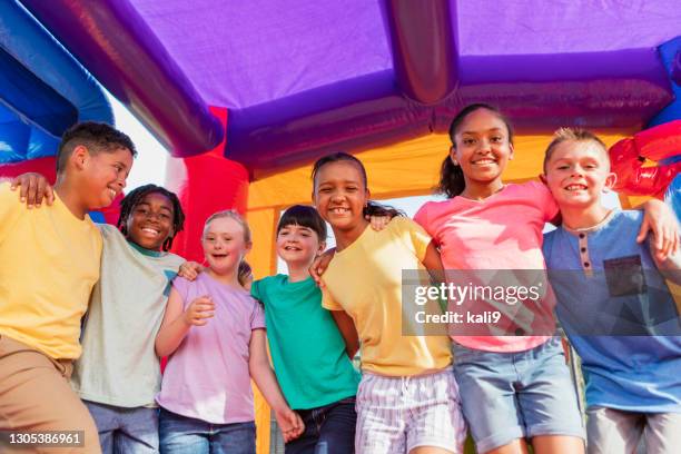 kinder im hüpfhaus, mädchen mit down-syndrom - inflatable playground stock-fotos und bilder