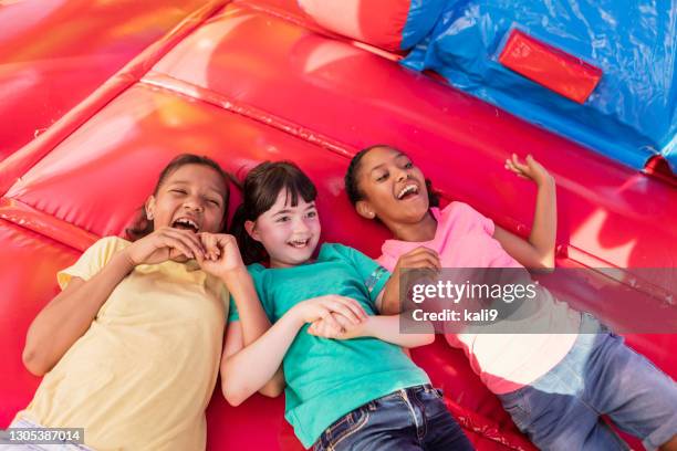 multi-etnische meisjes die in stuiterhuis spelen - alleen meisjes stockfoto's en -beelden
