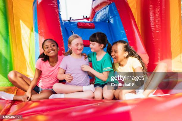 girl with down syndrome, friends in bounce house - inflatable playground stock pictures, royalty-free photos & images