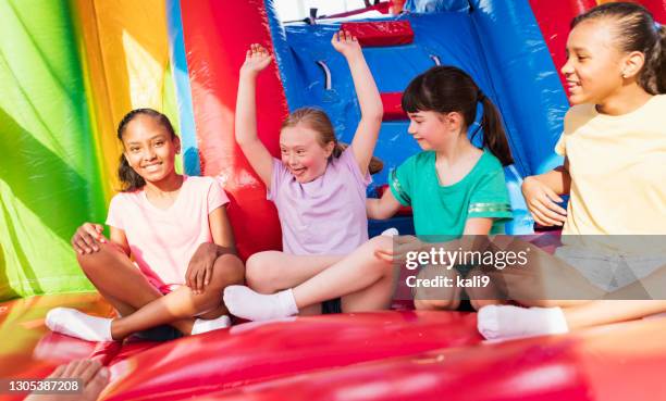 mädchen mit down-syndrom, freunde in bounce house - inflatable playground stock-fotos und bilder
