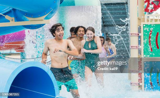 jugendliche werden im wasserpark-spielbereich nass - girls and boys playing in waterpark stock-fotos und bilder