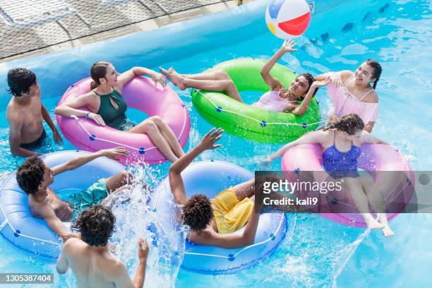 teenagers at water park playing in lazy river - inflatable playground stock pictures, royalty-free photos & images