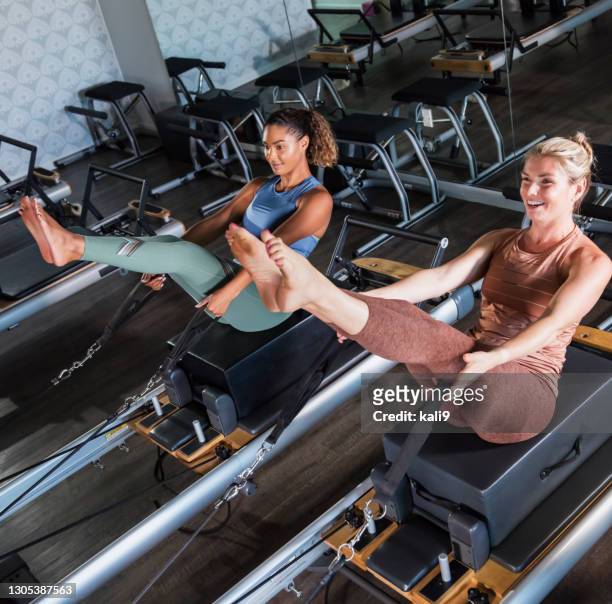 two women on pilates reformers - pilates equipment stock pictures, royalty-free photos & images