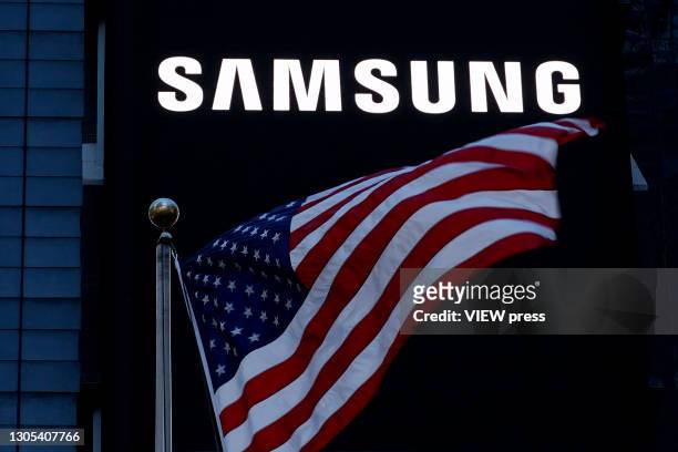Flag waves in front a Samsung logo in Times Square on March 04, 2021 in New York City. Samsung Electronics Co Ltd is considering four sites en United...