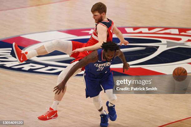 Davis Bertans of the Washington Wizards and Patrick Beverley of the Los Angeles Clippers collide during the second half at Capital One Arena on March...