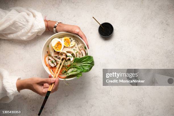 flat lay of noodle bowls with hands - asian cuisine japanese cuisine stock pictures, royalty-free photos & images