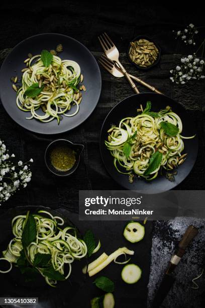 vlakke lay van courgette spaghetti op zwarte platen - mergpompoen stockfoto's en -beelden