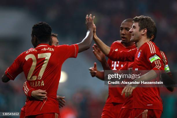 David Alaba of Muenchen celebrates scoring the second team goal with his team mates Thomas Mueller during the DFB Cup second round match between FC...