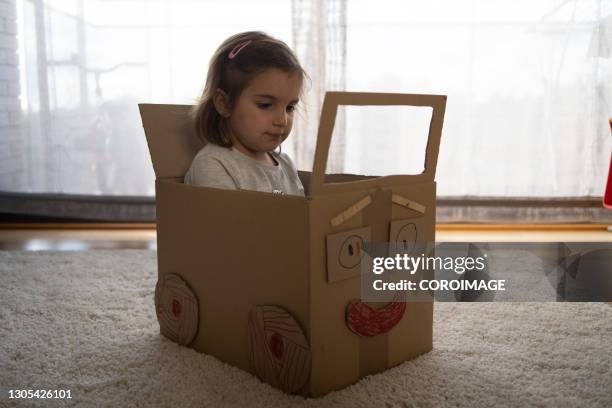 little girl playing driving a handmade cardboard car. - cardboard car stock pictures, royalty-free photos & images