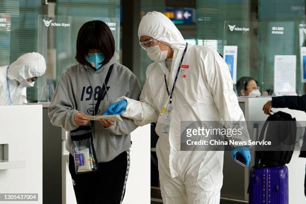 Worker wearing personal protective equipment talks to a passenger at Incheon international airport on March 4, 2021 in Incheon, South Korea.
