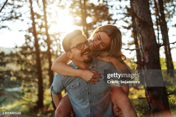 young and in love - park couple piggyback stock pictures, royalty-free photos & images
