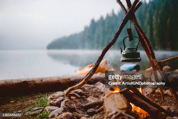 shot of a cute vintage teapot in a campsite near to lake. - leisure activity stock pictures, royalty-free photos & images
