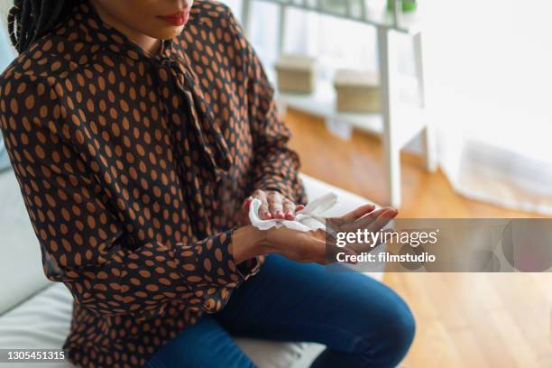 vrouw die handen met antiseptic doekjes desinfecteert - antiseptic wipe stockfoto's en -beelden