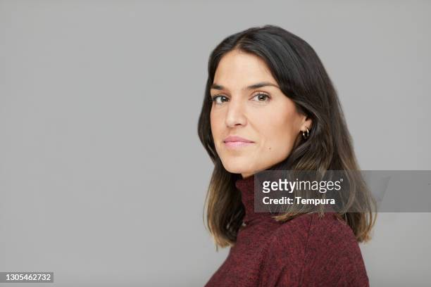 headshot studioportret van een vrouw in profiel dat de camera bekijkt. - business woman side stockfoto's en -beelden