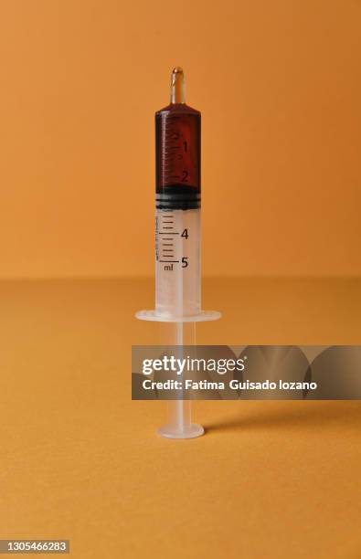 syringe with syrup on yellow background - syrup stock pictures, royalty-free photos & images