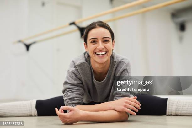 porträt des yogalehrers, der die splits macht und in die kamera lächelt. - spagat stock-fotos und bilder